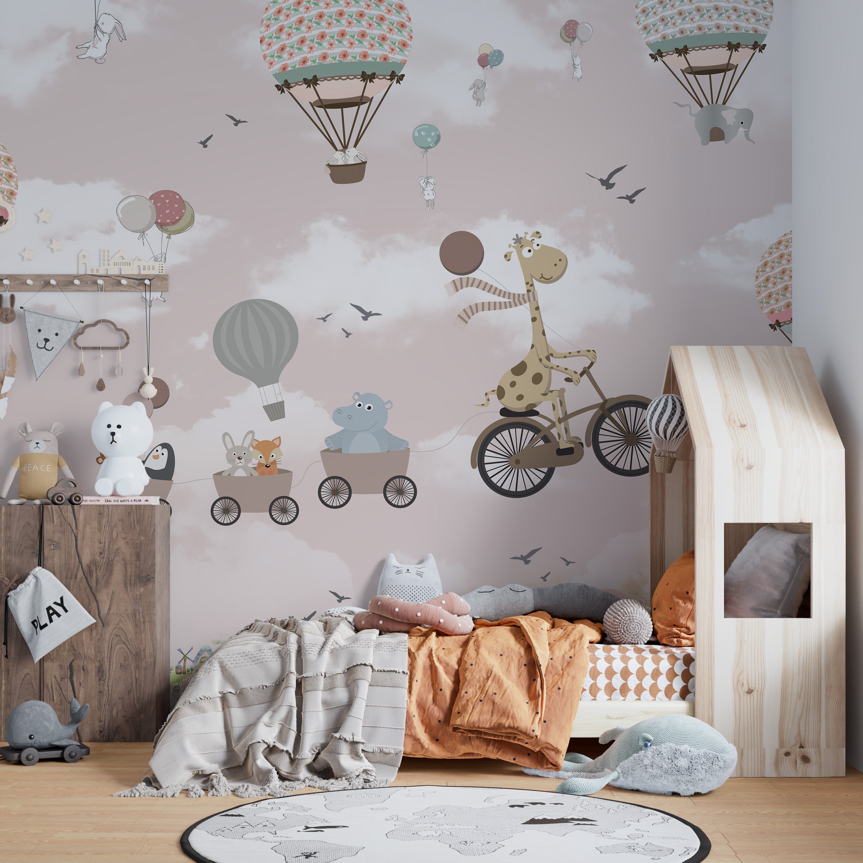 Pink-colored sky mural with safari animals in whimsical balloons.
